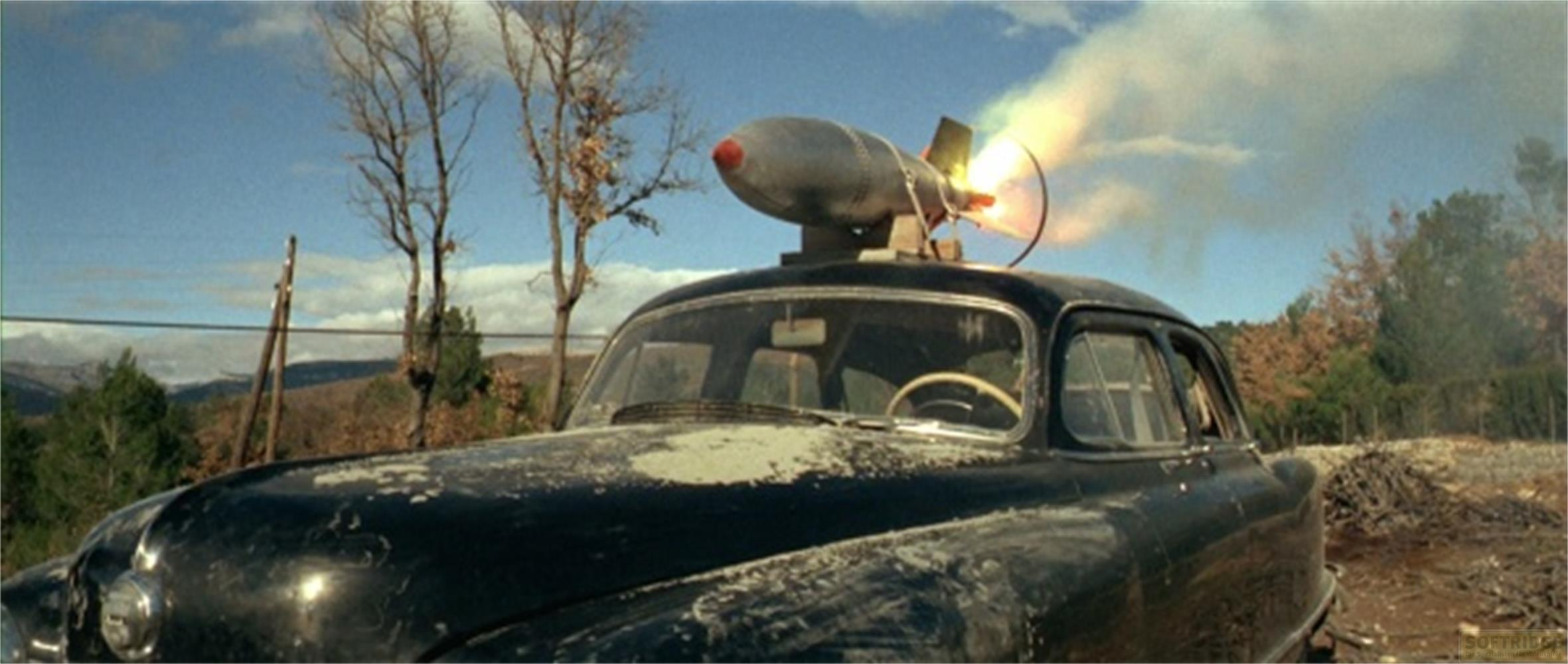 Un'auto nera con un missile sul tetto, che sputa fuoco.