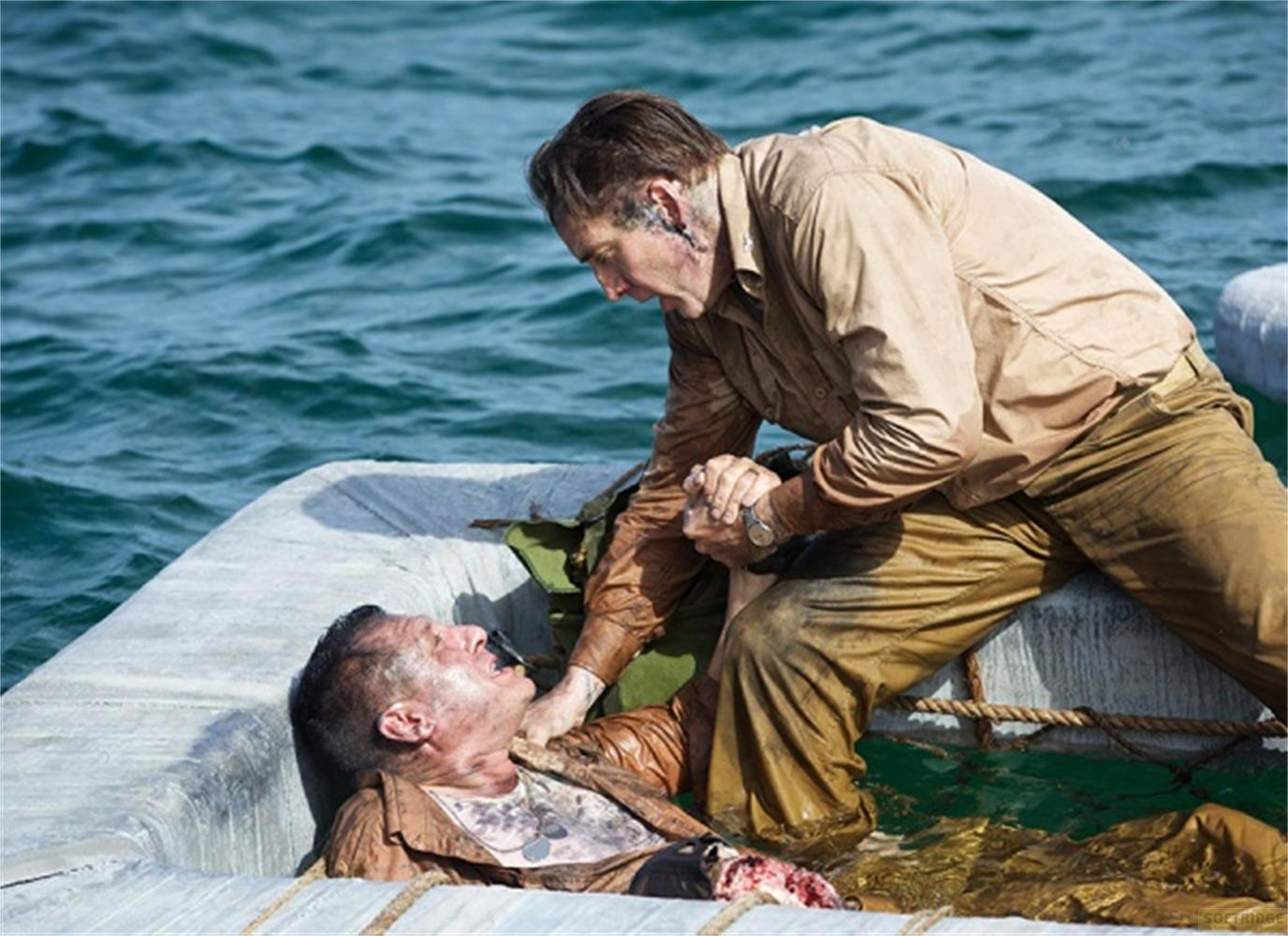 Un homme tire un homme blessé hors de l'eau dans un bateau.