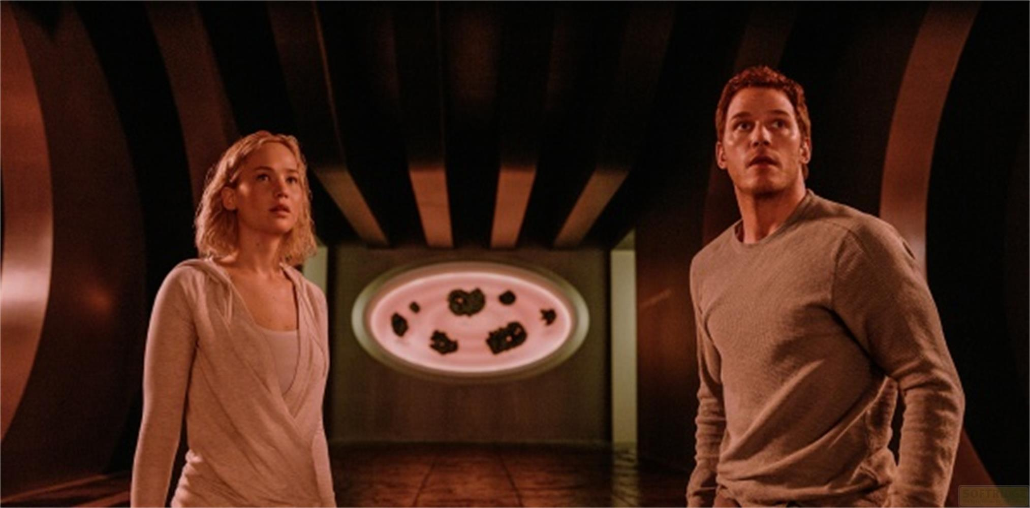 Un uomo e una donna in piedi in una stanza buia con uno schermo ovale.
