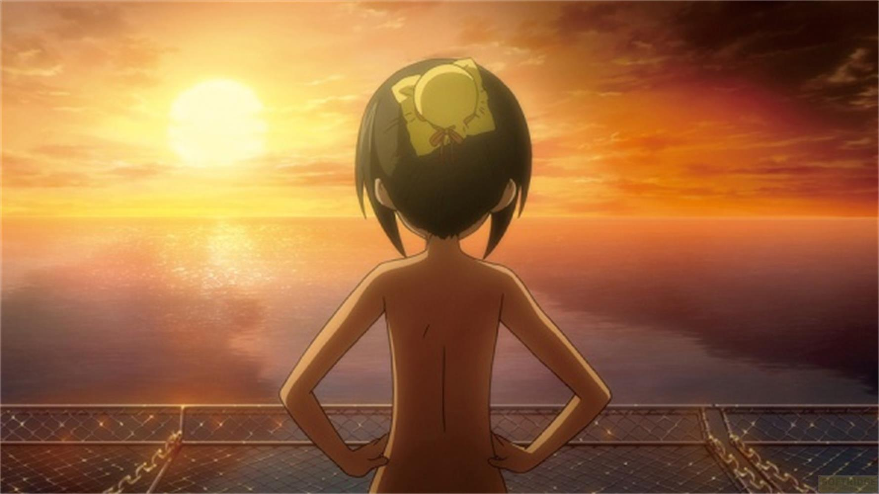 Una ragazza con un cappello giallo guarda il mare al tramonto.