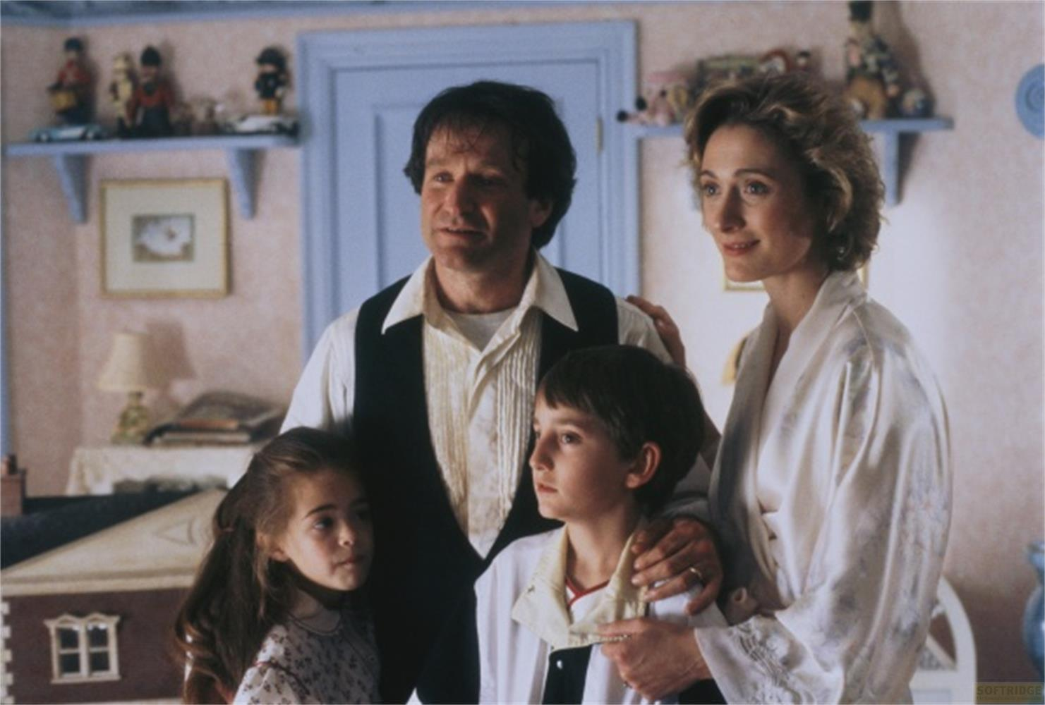 Une famille de quatre personnes, deux adultes et deux enfants, se tiennent ensemble dans une pièce.