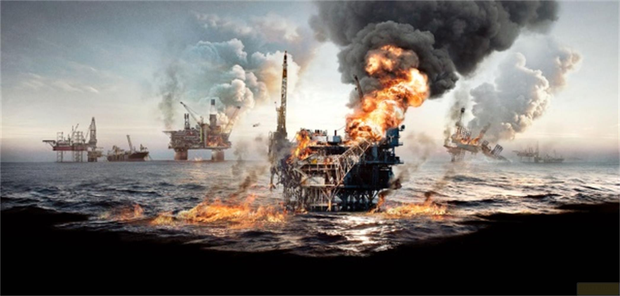 Diverse piattaforme petrolifere in mare, una in fiamme, fumo denso.