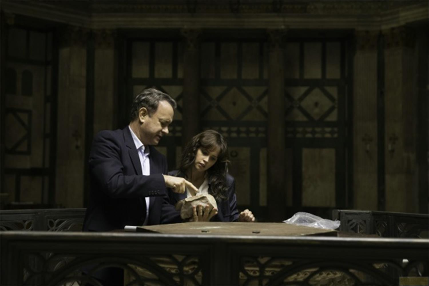 Un homme et une femme examinent un artefact sur une table dans une pièce sombre.