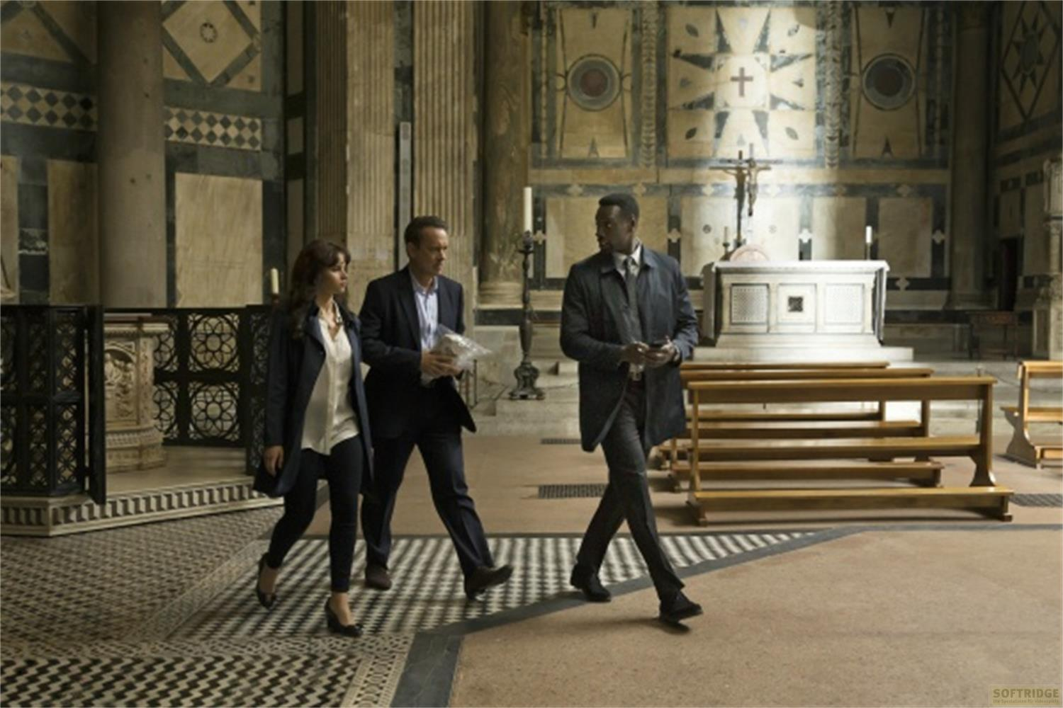 Trois personnes traversent une église. Un autel et des bancs sont à l'arrière-plan.