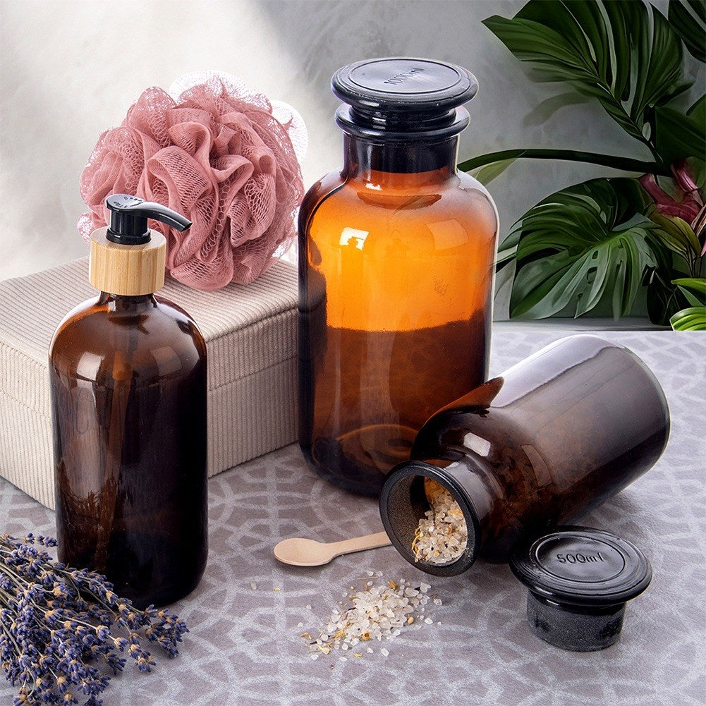 Botellas de vidrio marrón: una con bomba, una tumbada con sal, una de pie. Lavanda.
