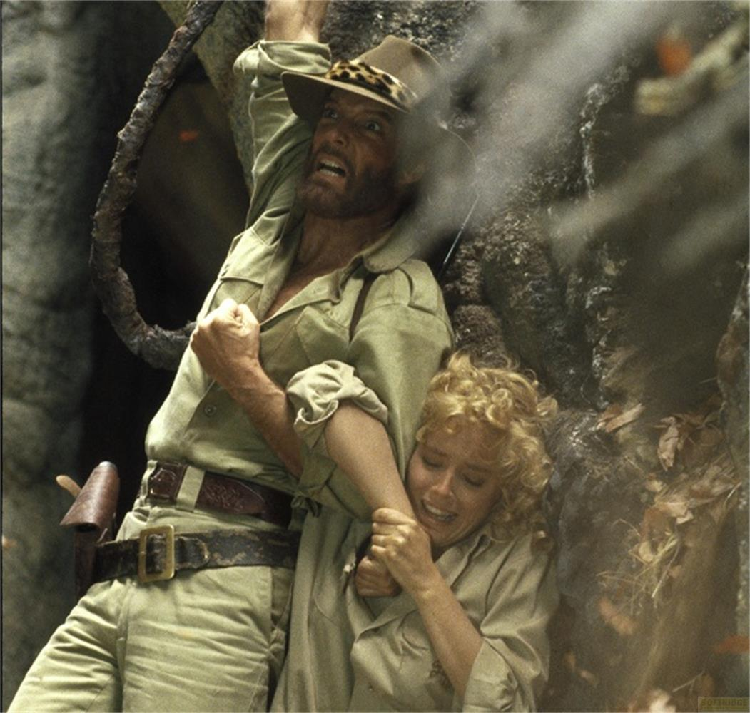 Un homme en chapeau se débat avec une femme dans la jungle.