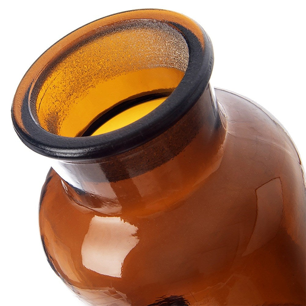 Primer plano de una botella de vidrio marrón con borde negro.