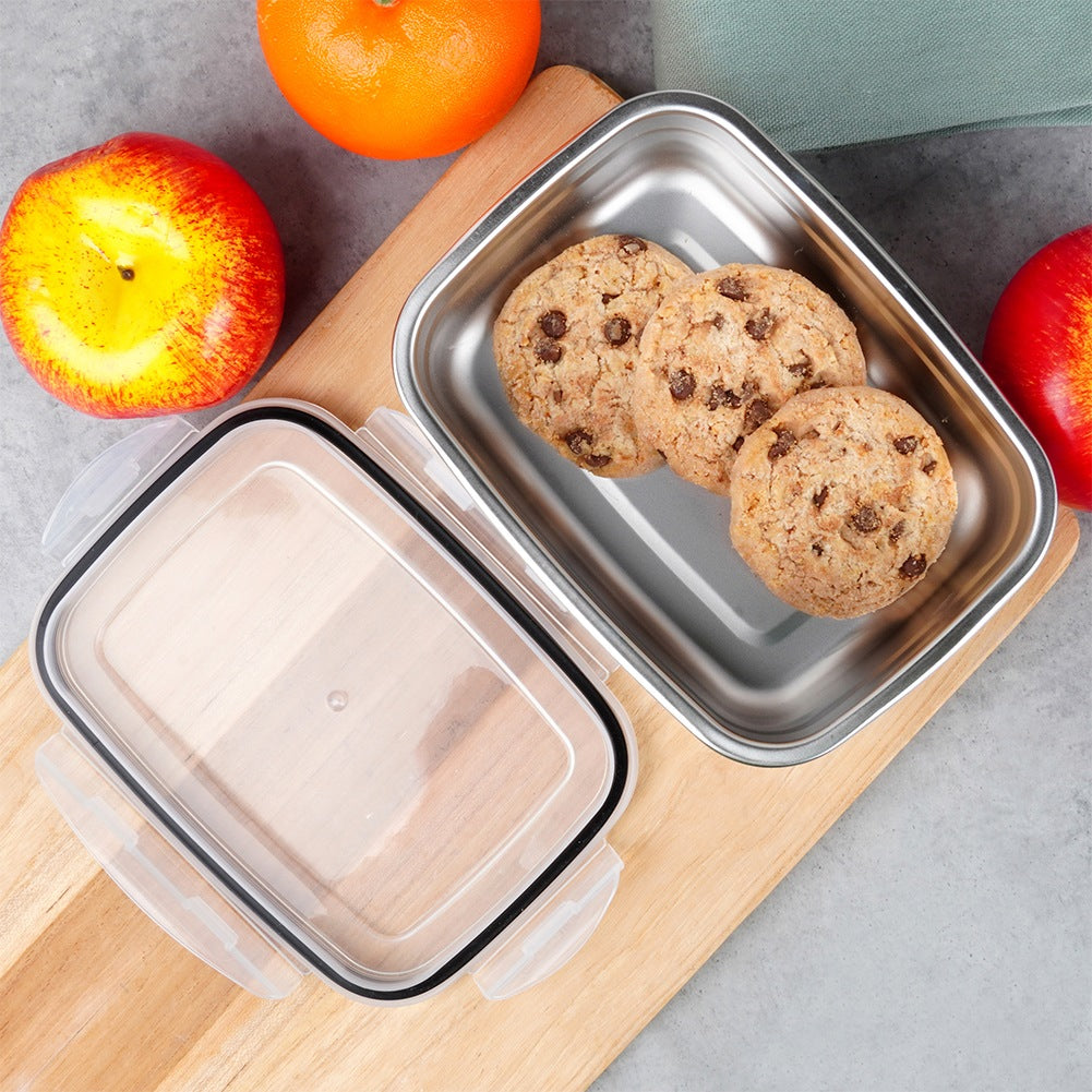 Un recipiente con galletas junto a manzanas y una naranja.