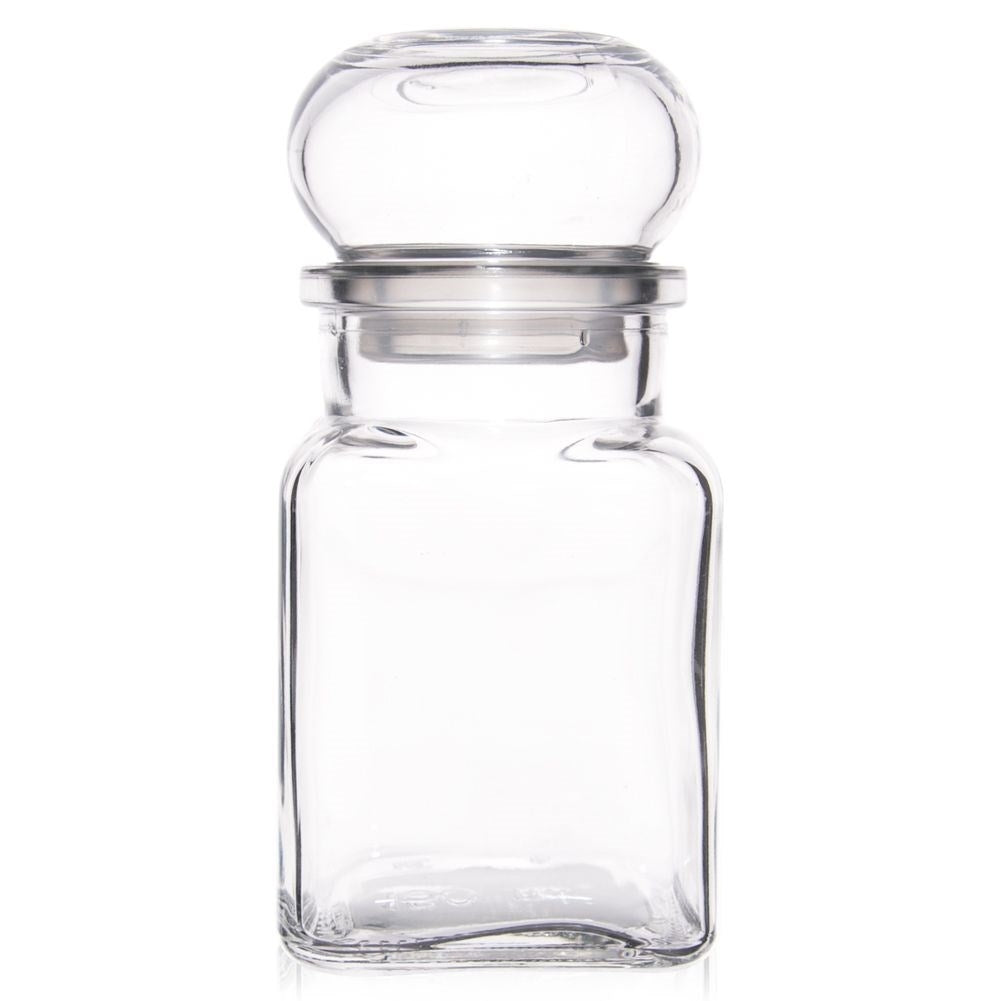 Una botella de vidrio vacía y transparente con borde plateado y tapa esférica.