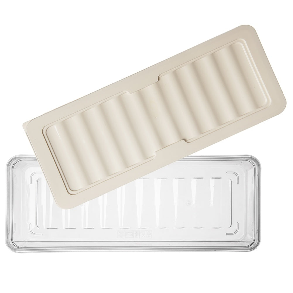 Una tapa beige con estrías yace sobre una caja de almacenamiento transparente.