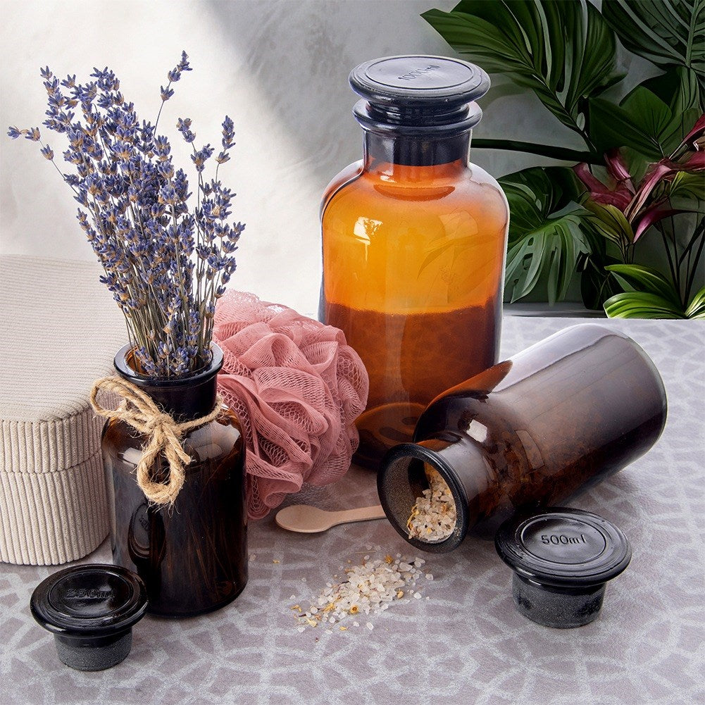 Botellas de vidrio ámbar con lavanda, esponja de baño y sal.