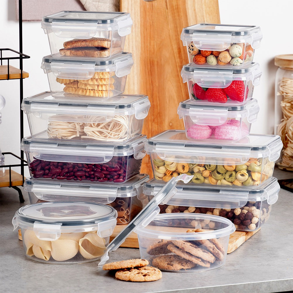 Múltiples recipientes transparentes apilados contienen alimentos como pasta, frijoles y galletas.