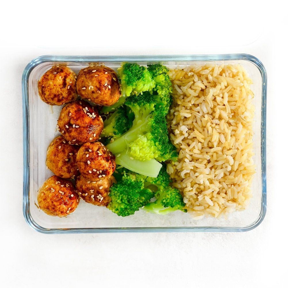 Albóndigas con brócoli y arroz en un recipiente de vidrio.
