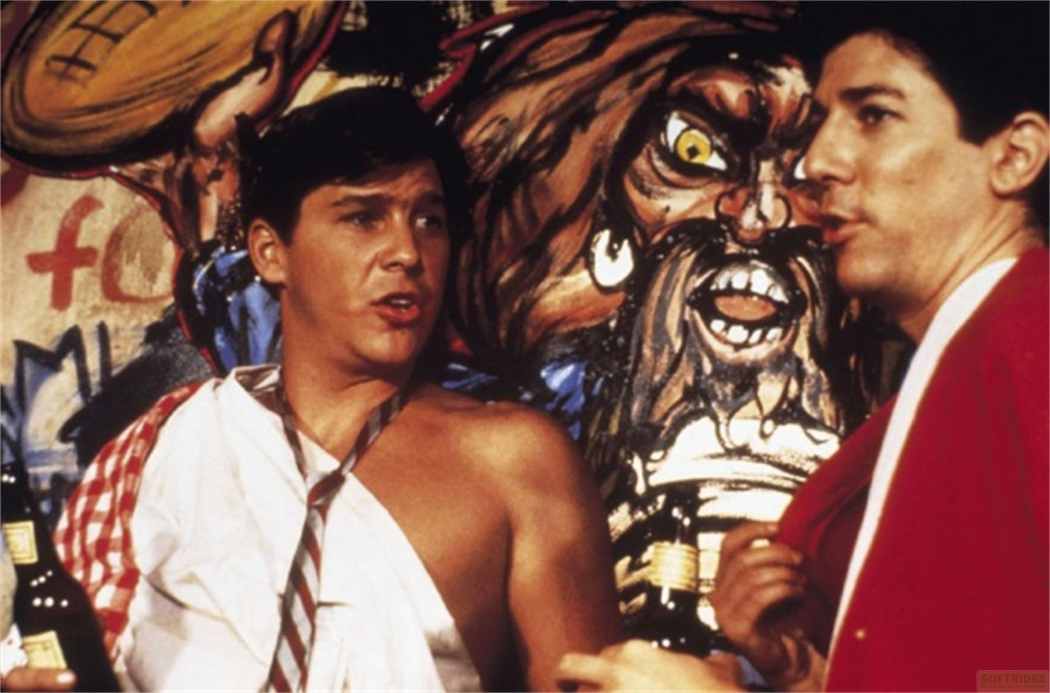 Due uomini davanti a un murale colorato con una faccia da mostro.