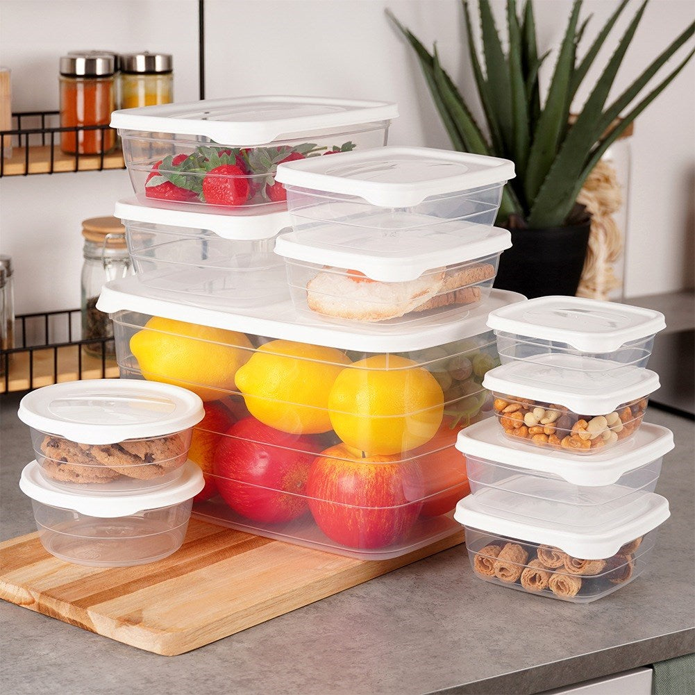 Comida en recipientes transparentes: bayas, limones, manzanas, galletas, nueces y pasteles.