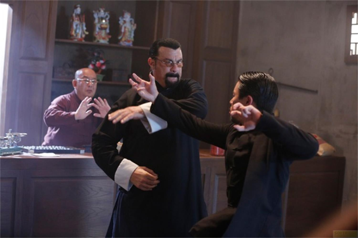 Tre uomini in abiti tradizionali praticano Kung Fu in una stanza con scaffali.