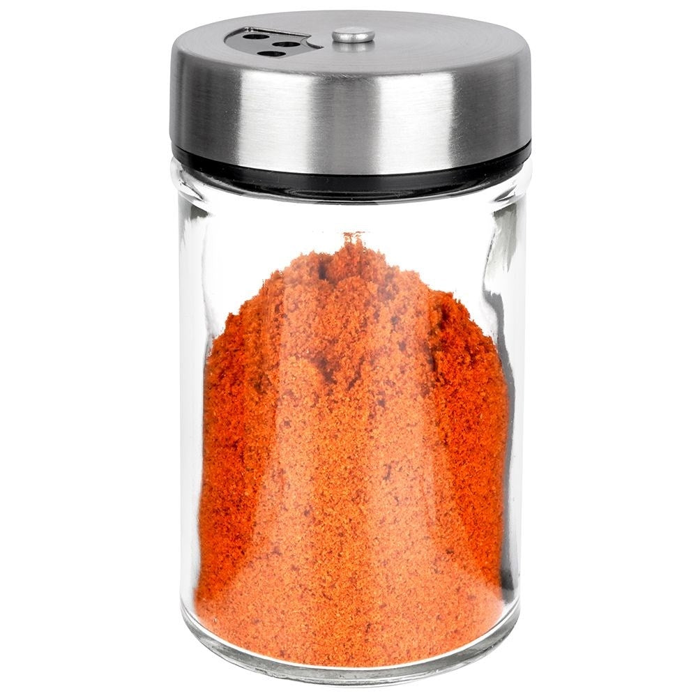 Un especiero de cristal lleno de pimentón naranja brillante.