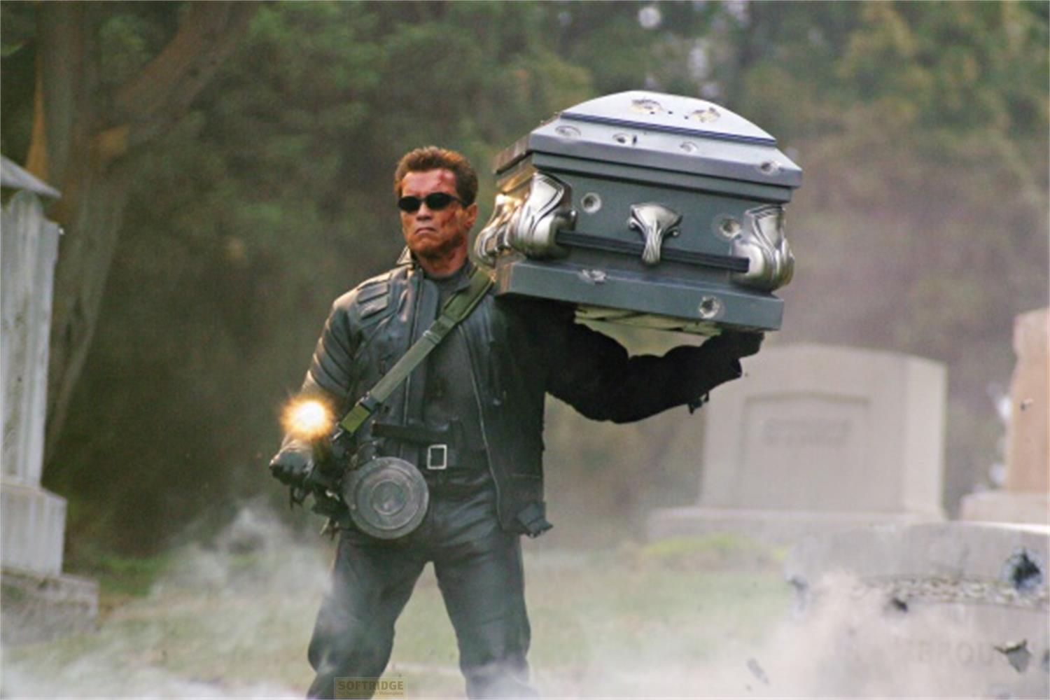 Arnold Schwarzenegger porte un cercueil dans un cimetière, armé.