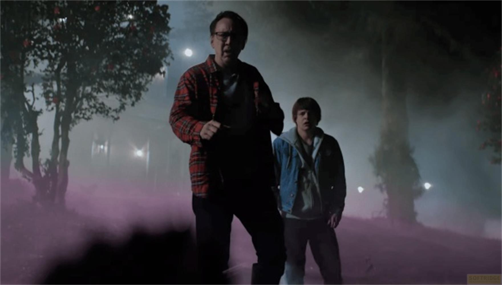 Uomo con camicia a quadri e un ragazzo in nebbia vicino agli alberi.
