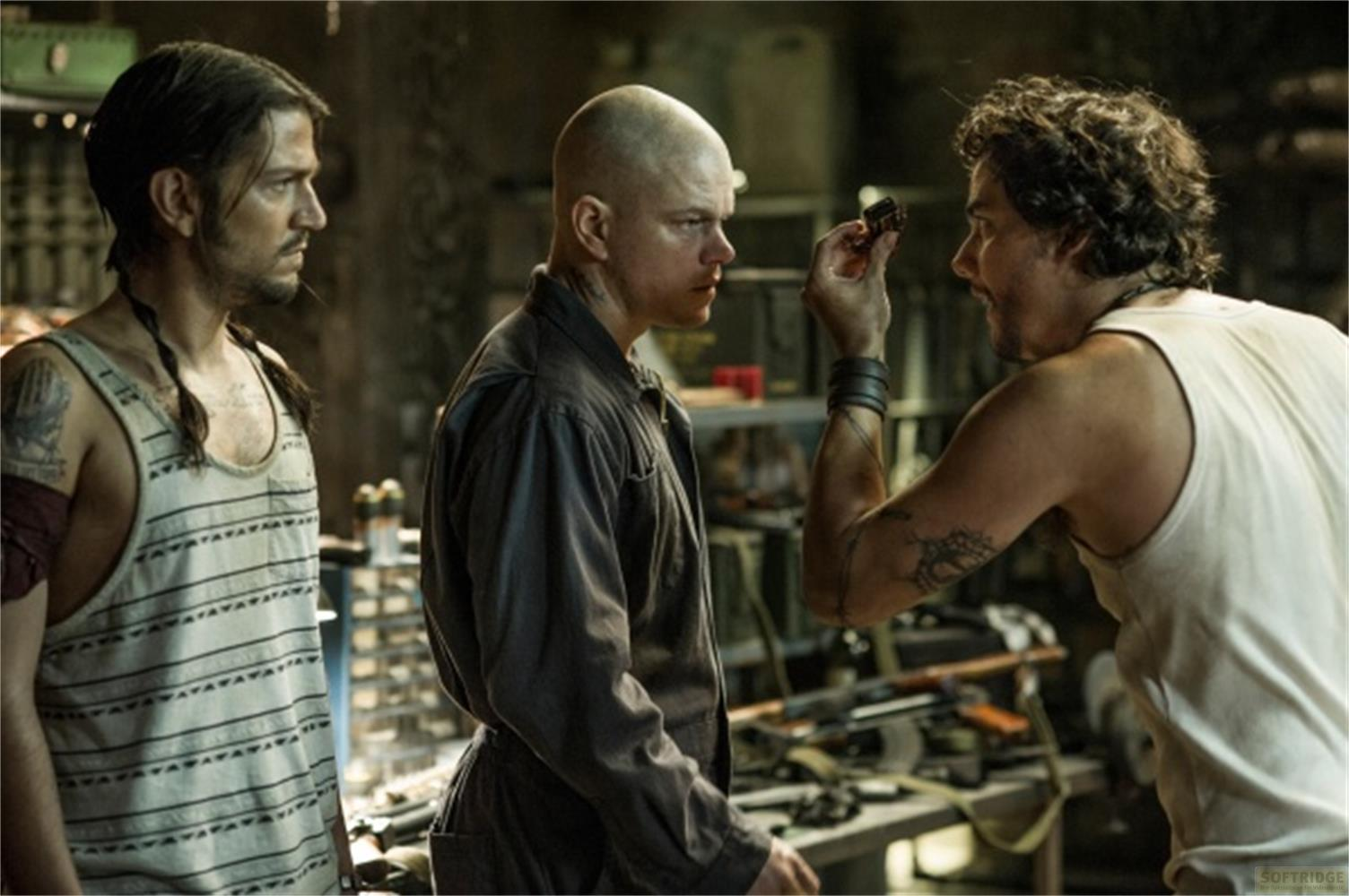 Trois hommes dans un atelier, l'un tenant un objet.