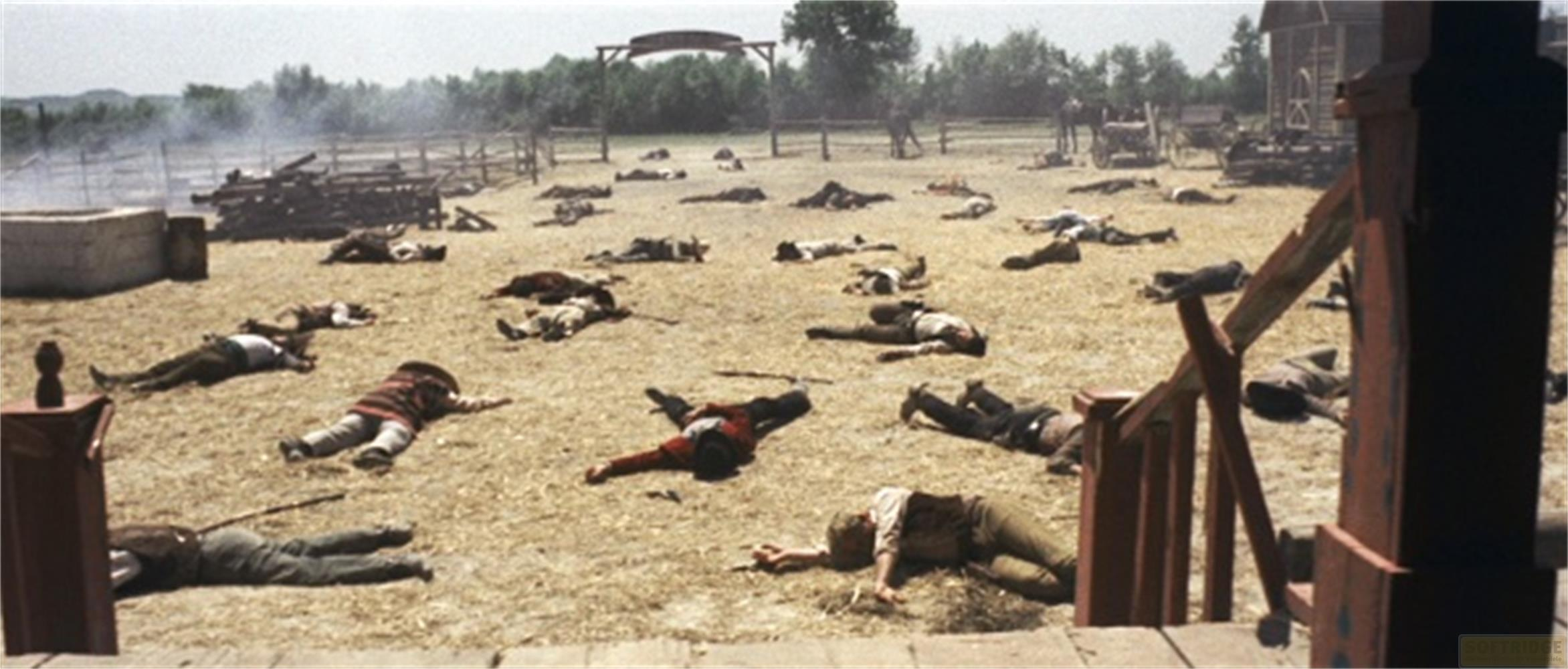 Molti uomini morti giacciono a terra in una polverosa città del selvaggio West.