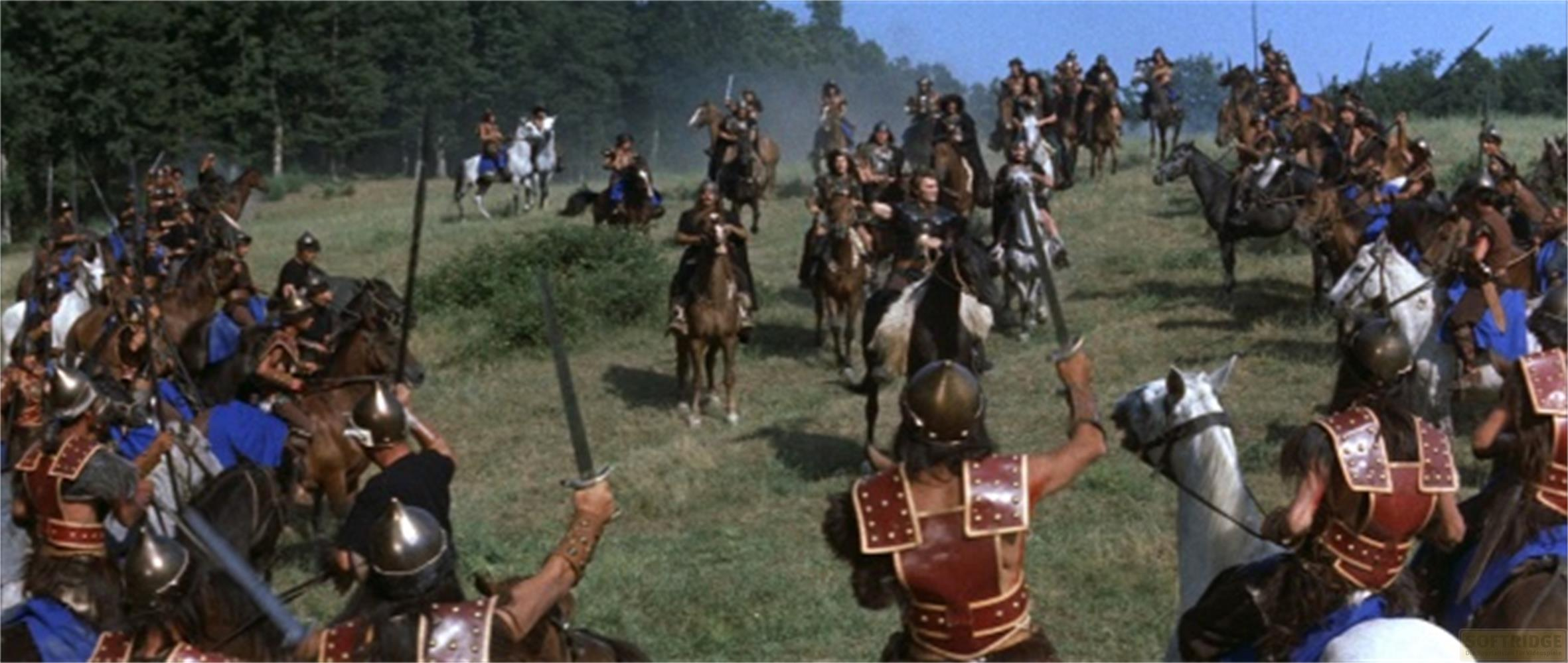 Un gruppo di guerrieri a cavallo cavalca in un campo con alberi sullo sfondo.