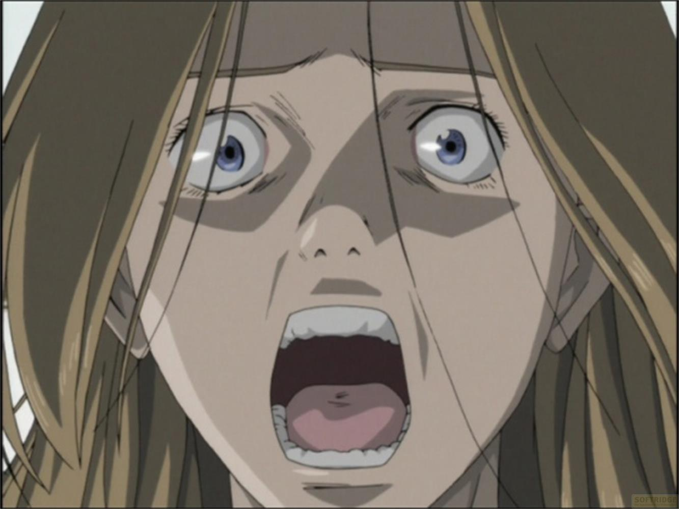 Primo piano di un viso anime femminile spaventato con occhi blu spalancati e bocca aperta.