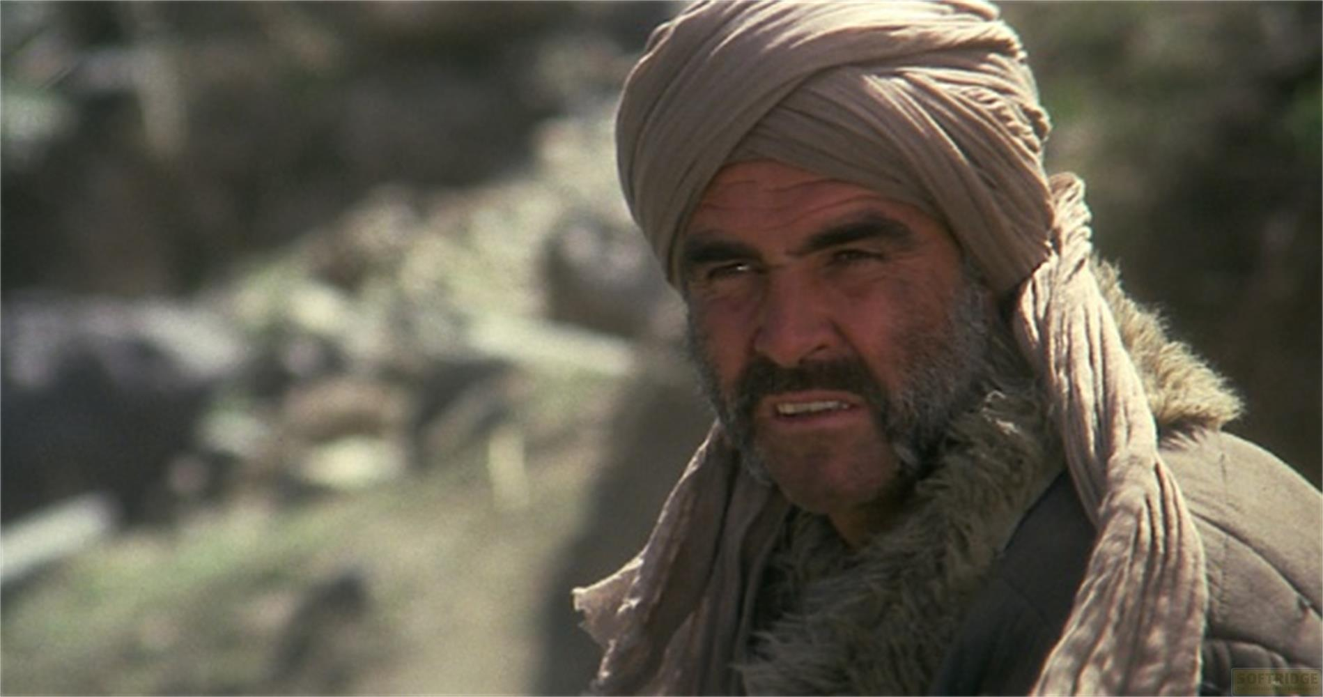 Un homme barbu et en turban regarde à gauche. Il porte de la fourrure.
