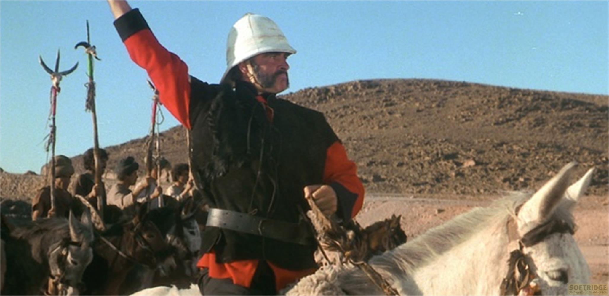 Un homme en tenue coloniale monte un âne blanc dans un paysage désertique.
