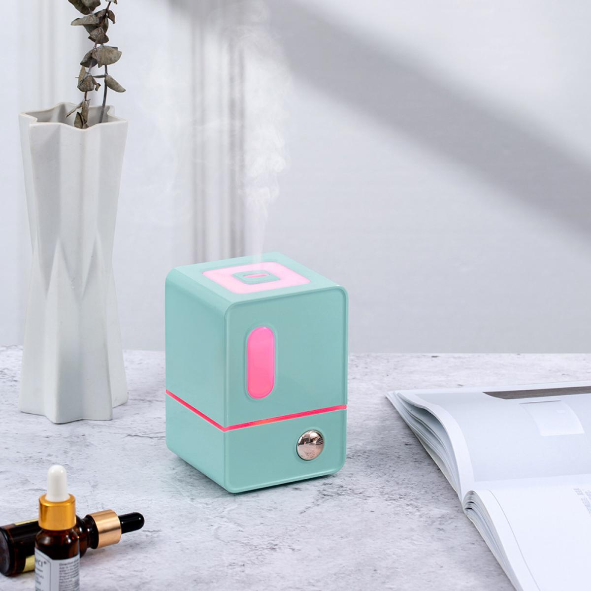 Ein türkisfarbener Diffusor mit rosa Lichtern gibt Dampf ab.