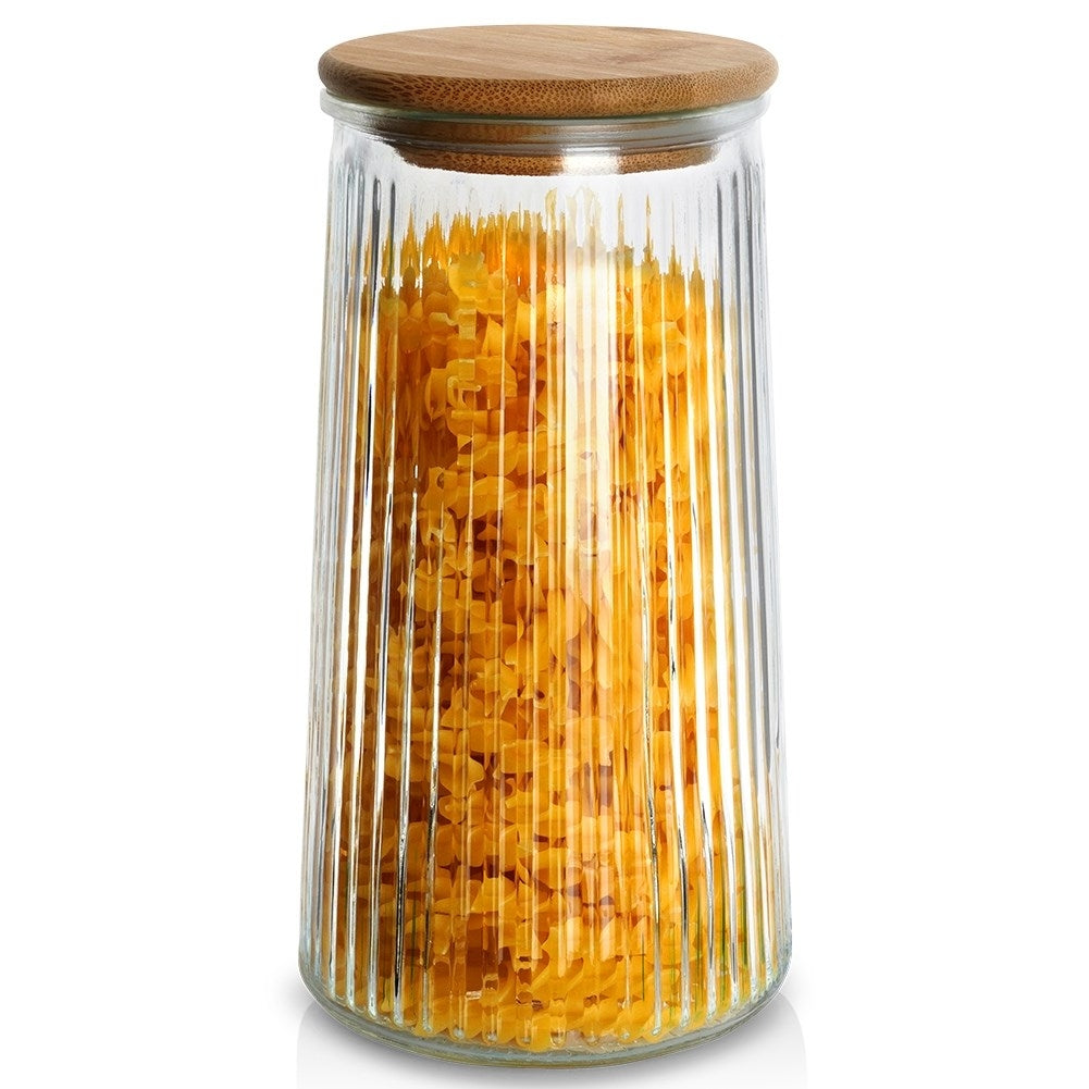 Un barattolo di vetro scanalato verticalmente, pieno di pasta gialla e coperchio in legno.