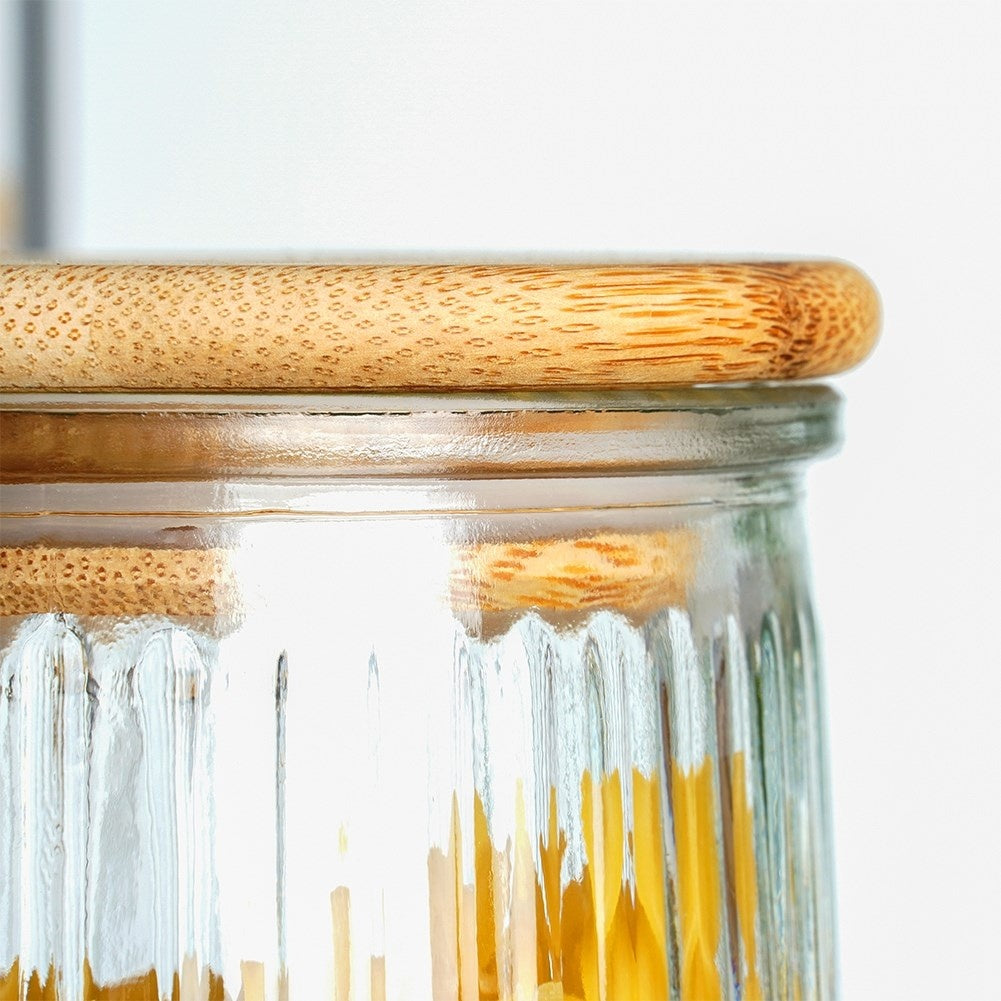 Un barattolo di vetro con coperchio in legno, pieno di pasta.