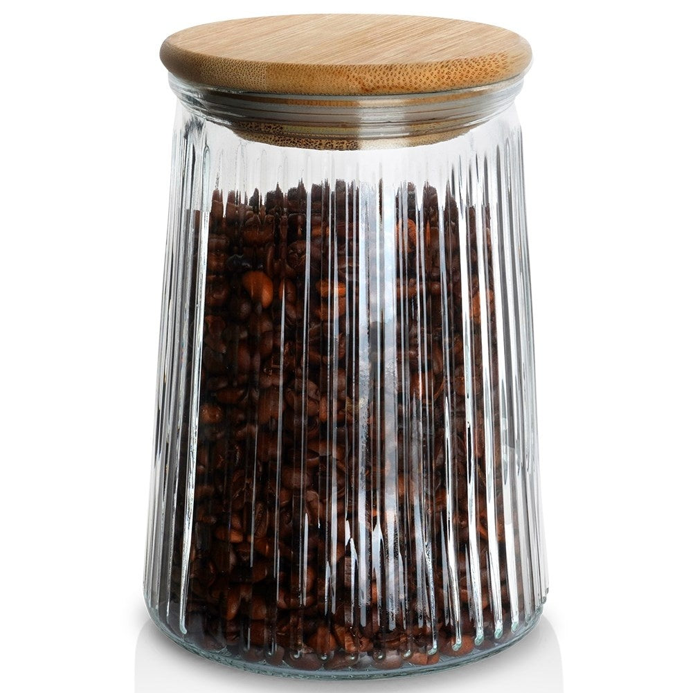 Un barattolo di vetro con coperchio in bambù, riempito con chicchi di caffè.