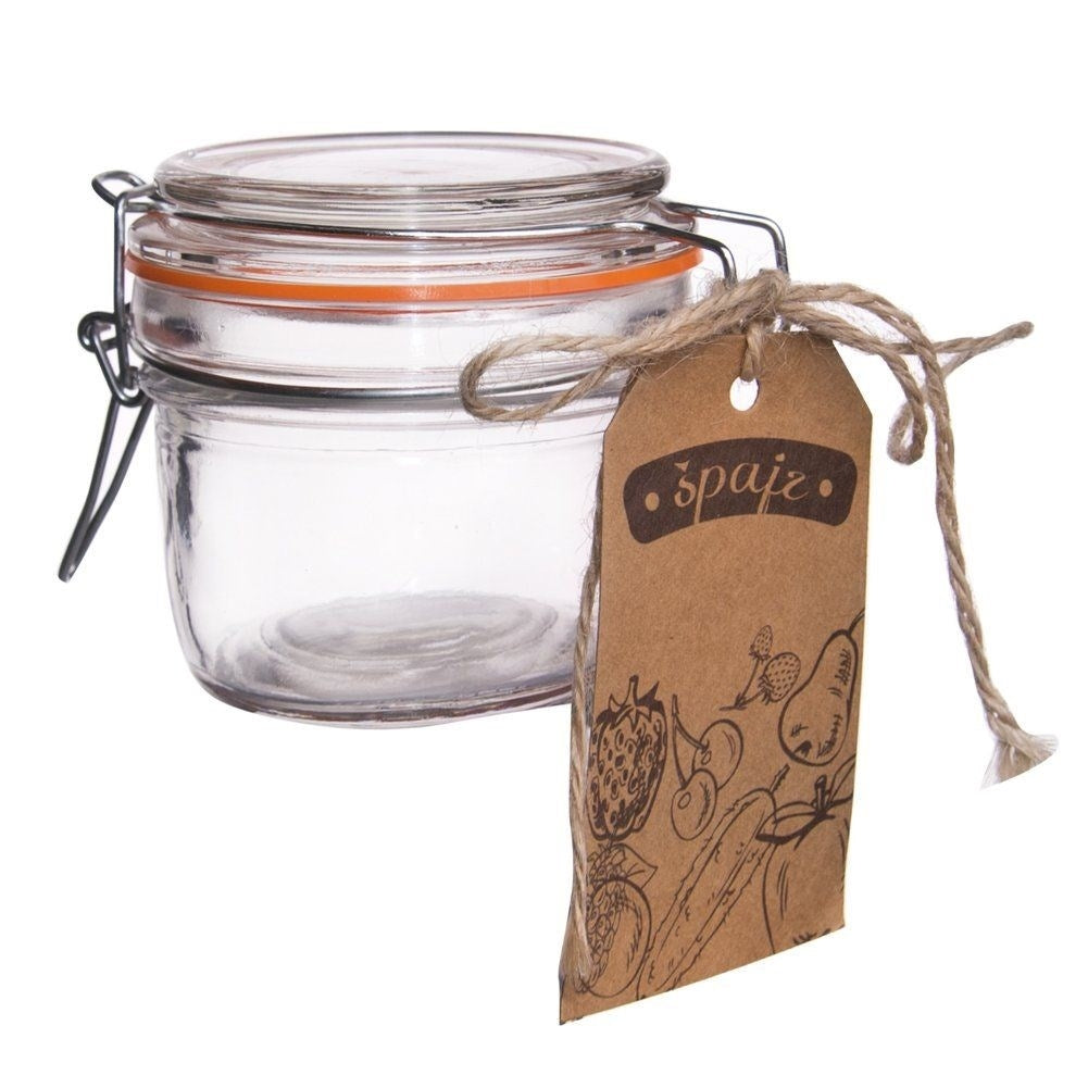 Un frasco de vidrio vacío con tapa abatible y etiqueta marrón con dibujos de frutas.