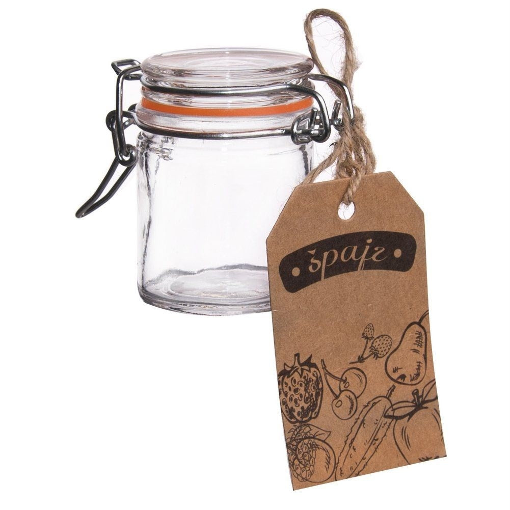Un pequeño tarro de cristal con tapa abatible y etiqueta marrón con dibujos de frutas.