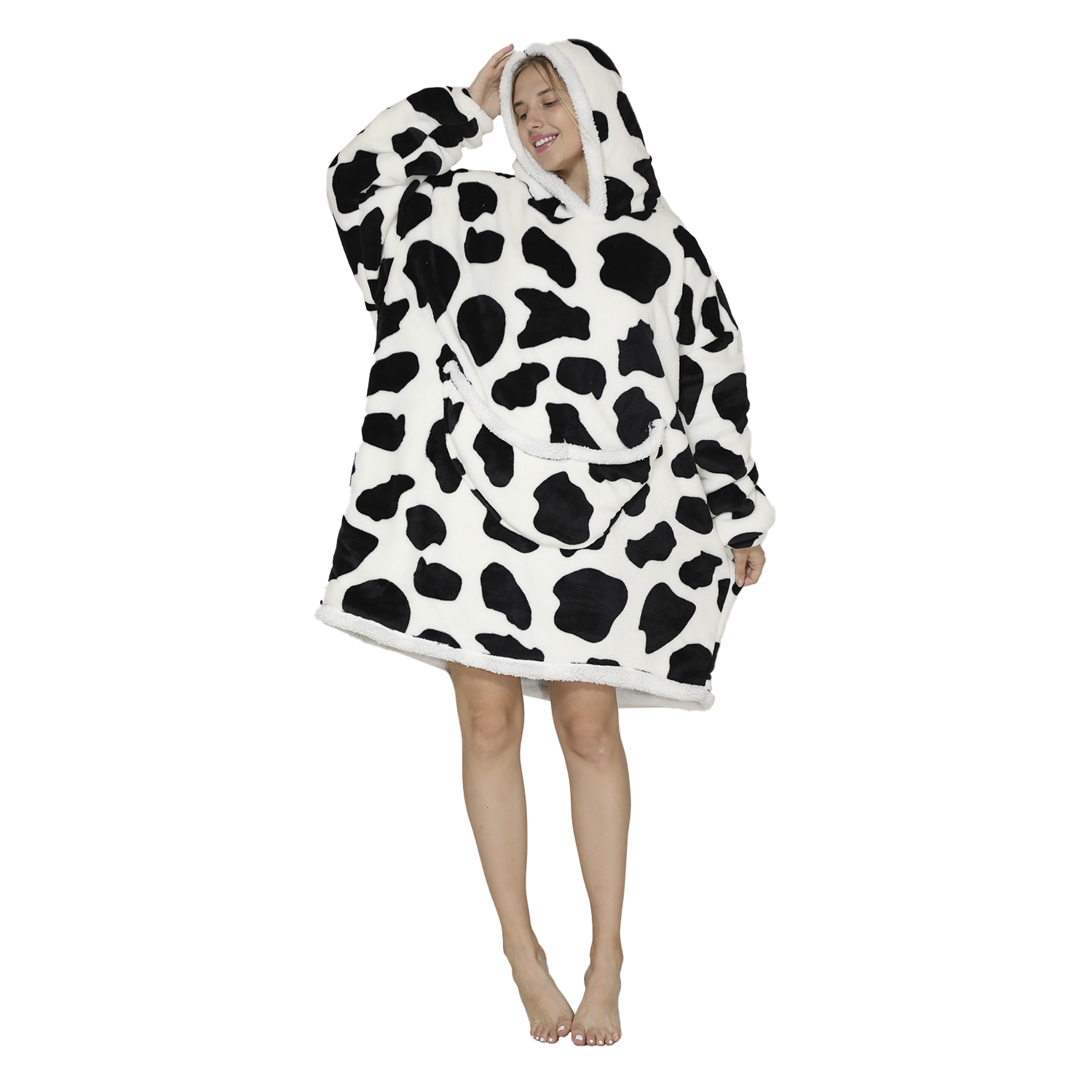 Mujer con sudadera extragrande de estampado de vaca, tocándose el pelo.