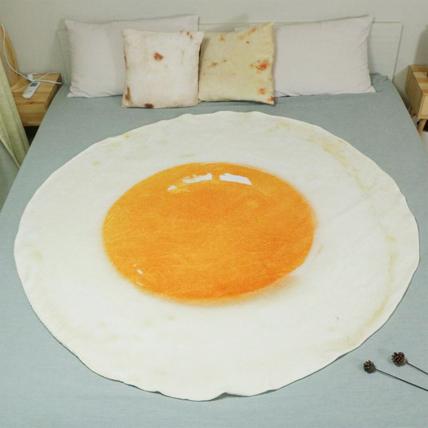 Un letto con una coperta a forma di uovo fritto. Aree bianche e arancioni.