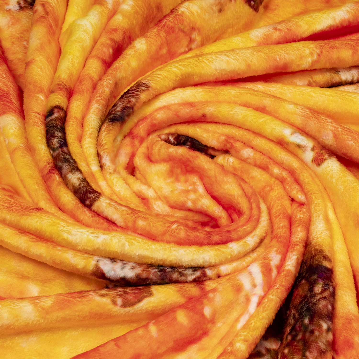 Nahaufnahme einer weich gefalteten Decke in Orange- und Gelbtönen mit braunen Flecken.