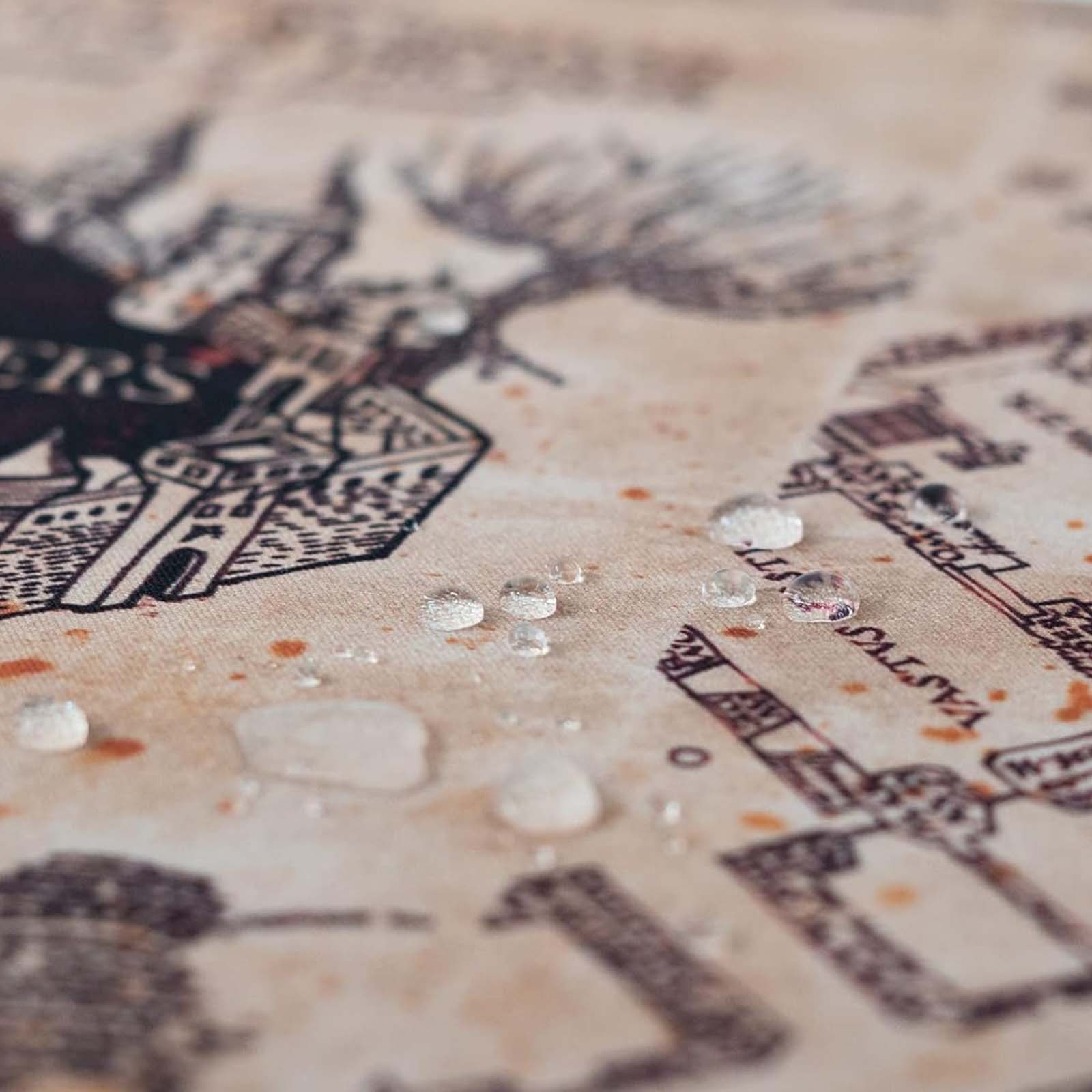 Gocce d'acqua su una vecchia mappa che mostra edifici e schizzi marroni.