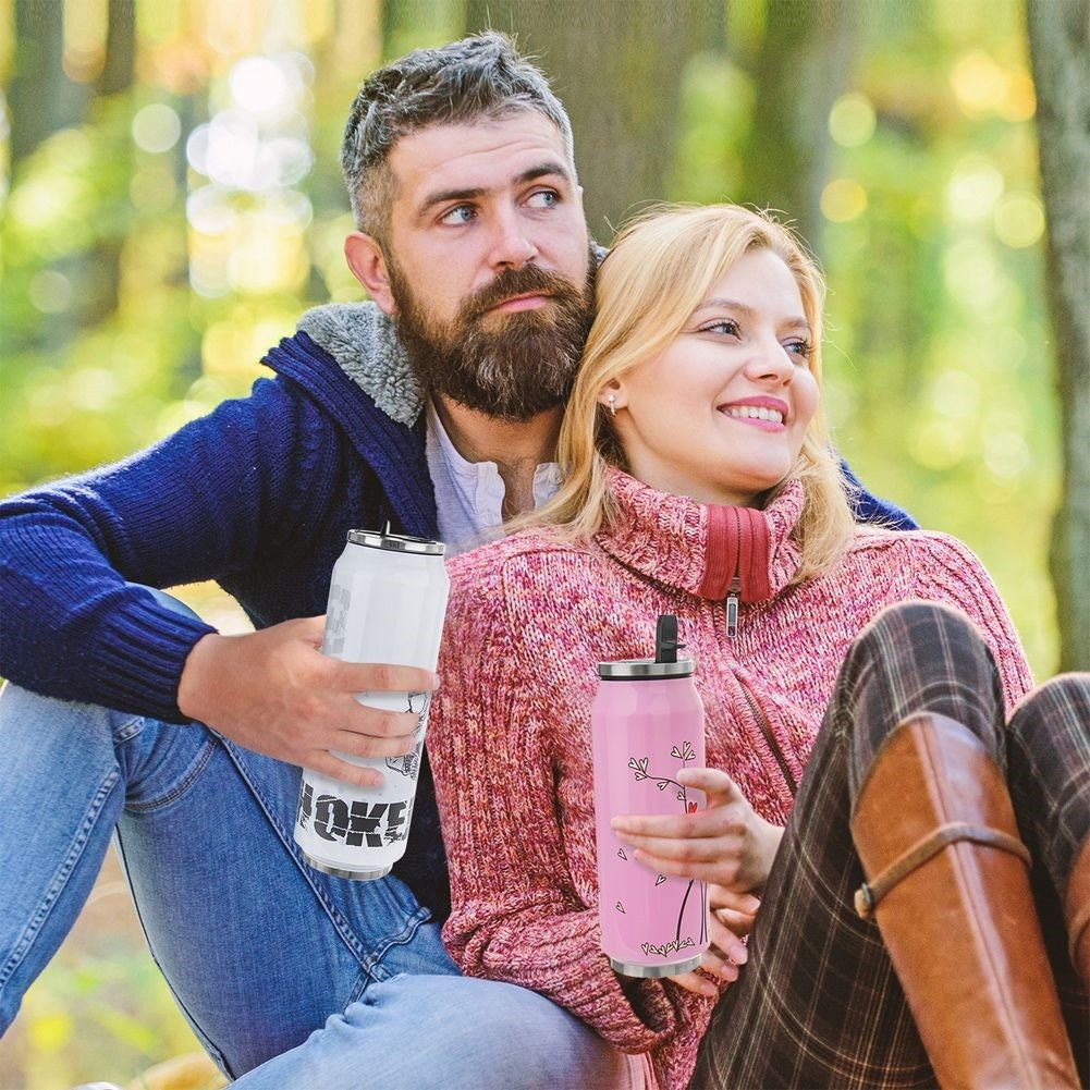 Un hombre y una mujer sentados al aire libre con vasos térmicos.