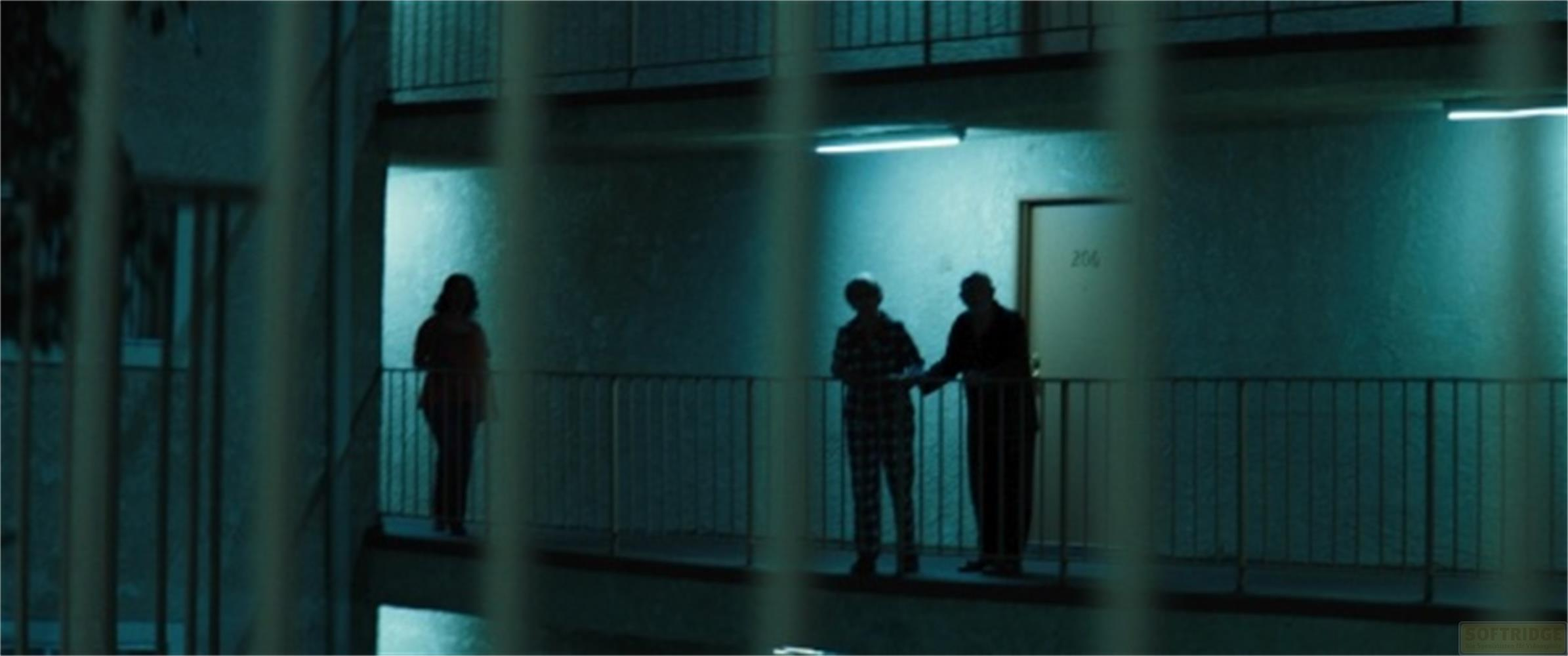 Tre persone stanno su un balcone di fronte a un edificio.