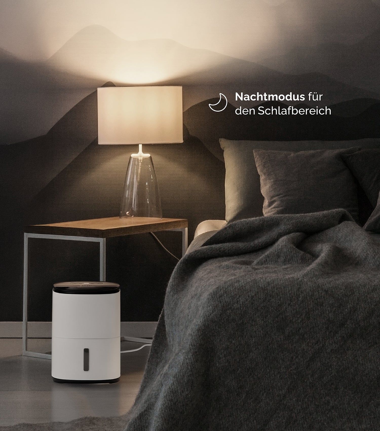Un comodino con una lampada accanto a un letto con umidificatore.