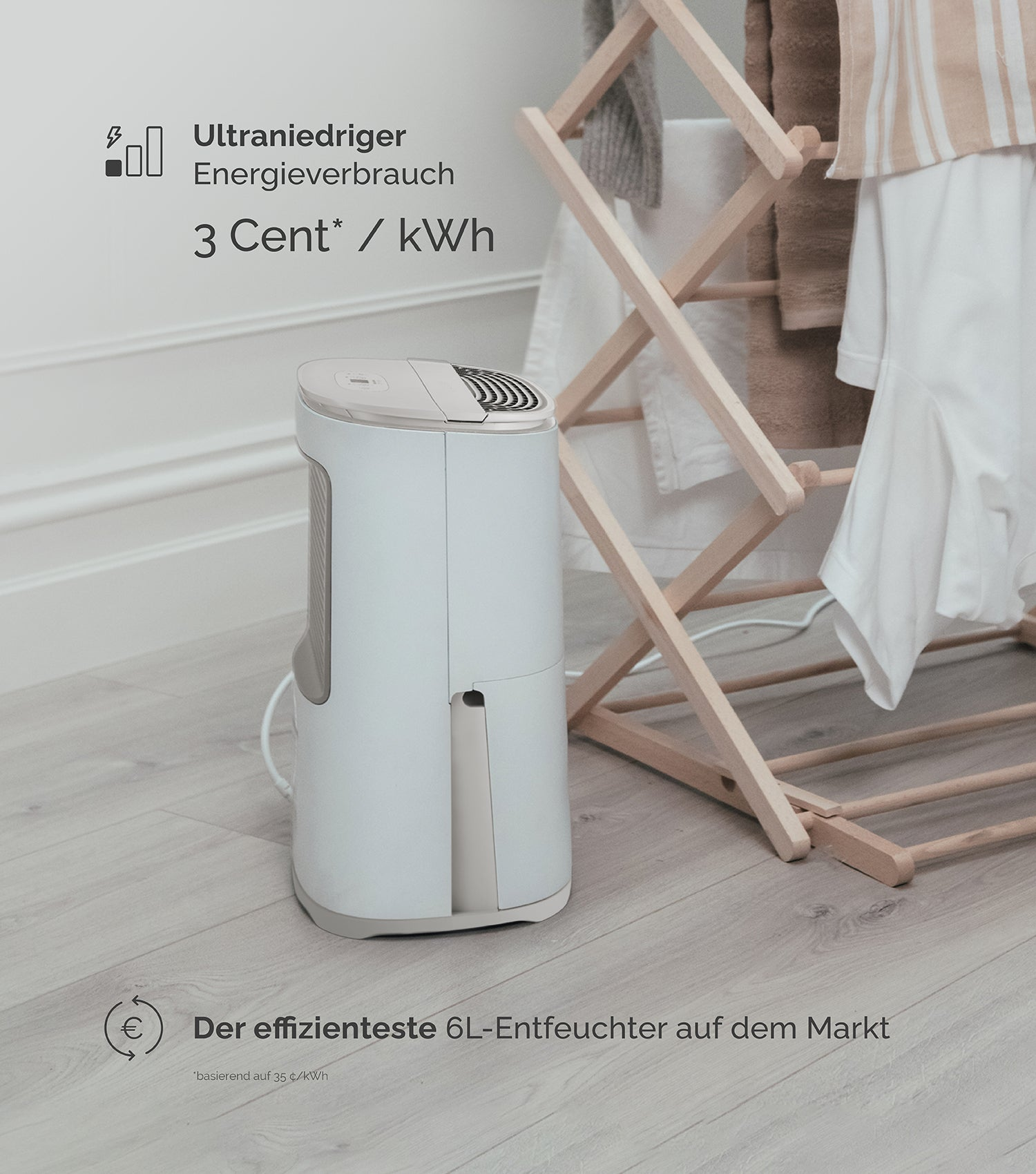 Ein weißer Luftentfeuchter steht neben einem Holz-Wäscheständer mit Handtüchern.