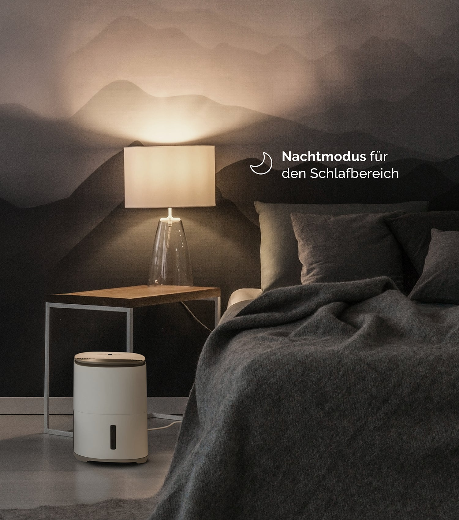 Ein Nachttisch mit Lampe und Luftbefeuchter neben einem Bett.