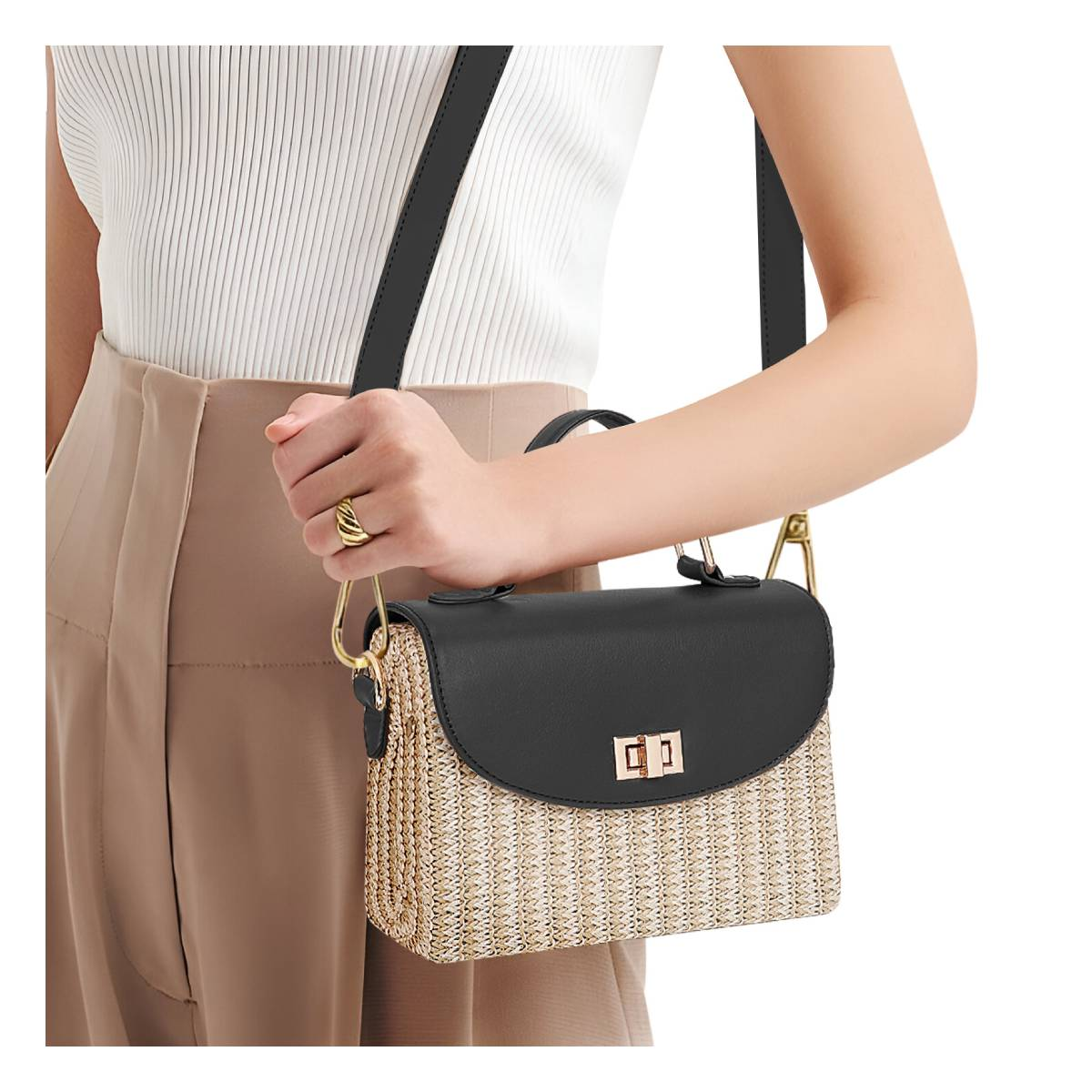Eine Frau trägt eine Stroh-Handtasche mit schwarzem Deckel und goldenen Beschlägen.