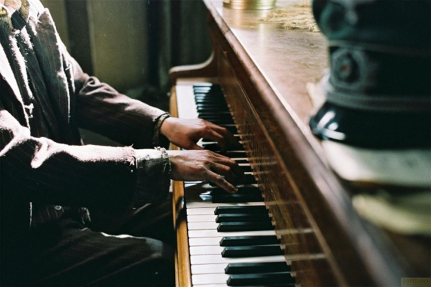 Una persona suona il pianoforte. Primo piano delle mani sui tasti.