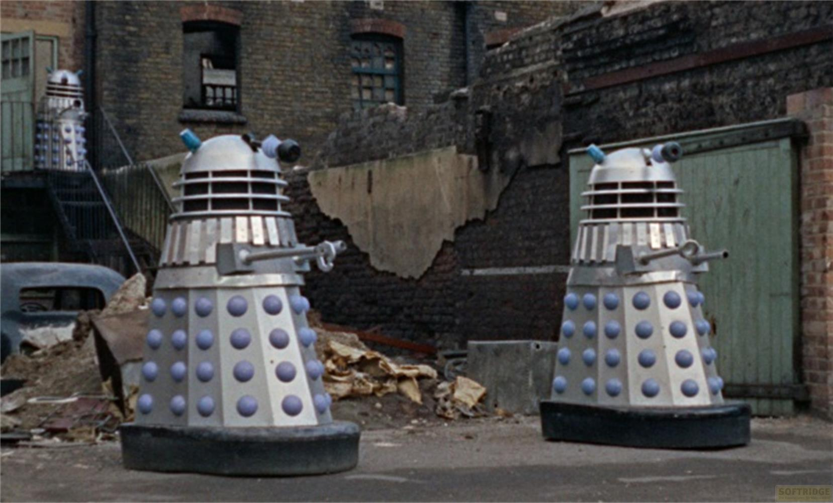 Due Dalek si trovano in un vicolo distrutto. Uno è sulle scale.