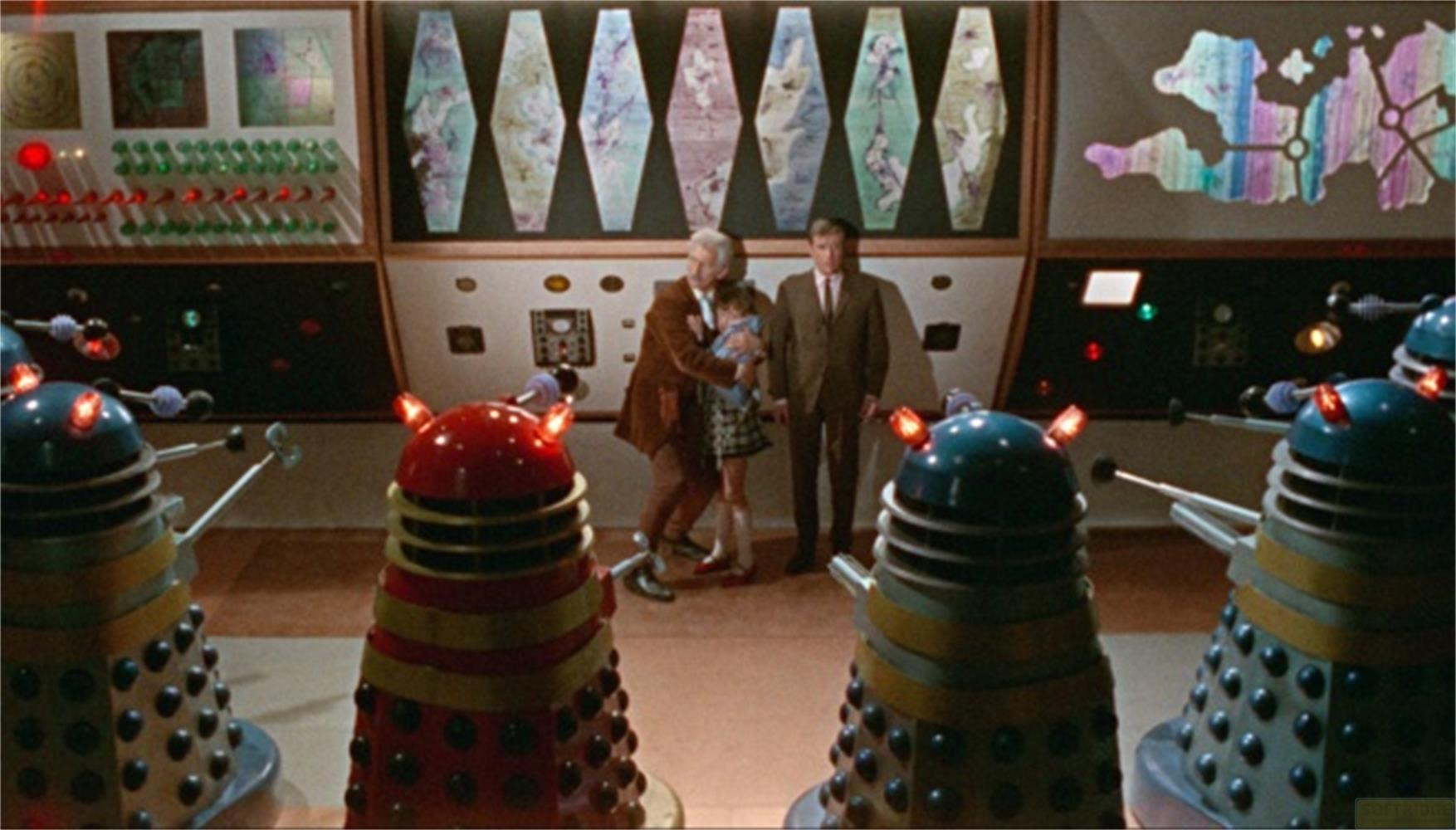 Persone e Dalek in una sala di controllo con schermi.