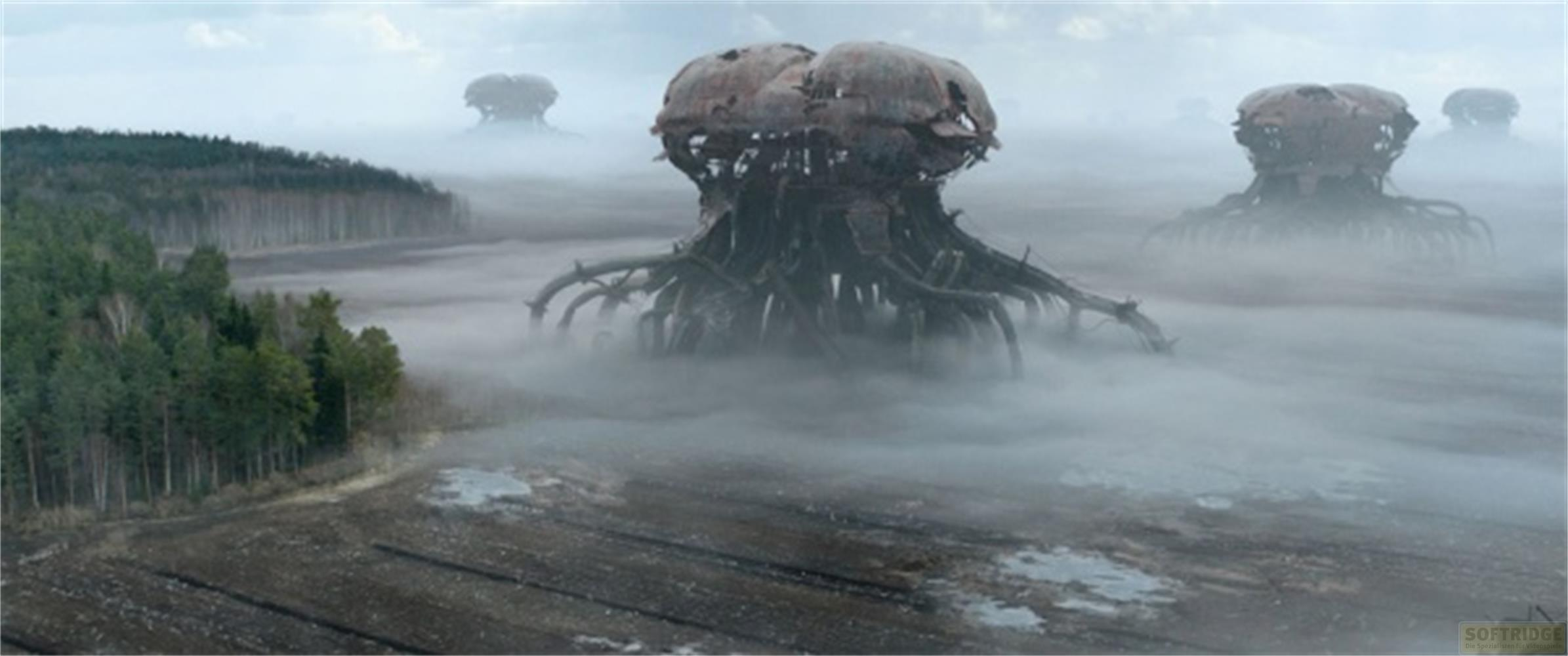 Eerie, enormi macchine si ergono nella nebbia su un campo.