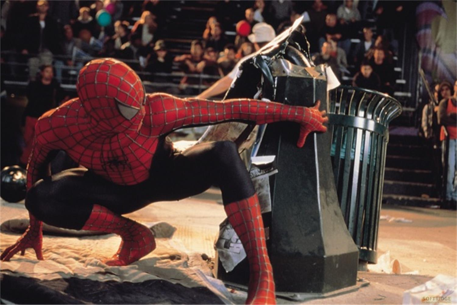 Spider-Man s'accroupit près d'une poubelle avec une foule en arrière-plan.